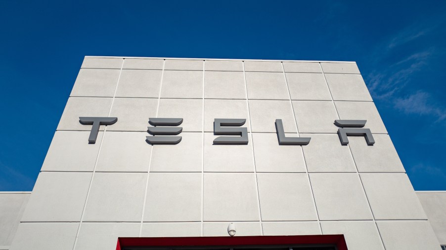 Low-angle view of the façade of a Tesla Motors dealership with logo and sign in Pleasanton, California, on July 23, 2018