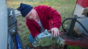 A man connecting a trailer to a truck tow hitch