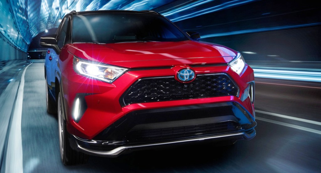 a red 2021 Toyota RAV4 Prime is one of the best Toyota crossover SUV models shown here in red driving at speed in a tunnel