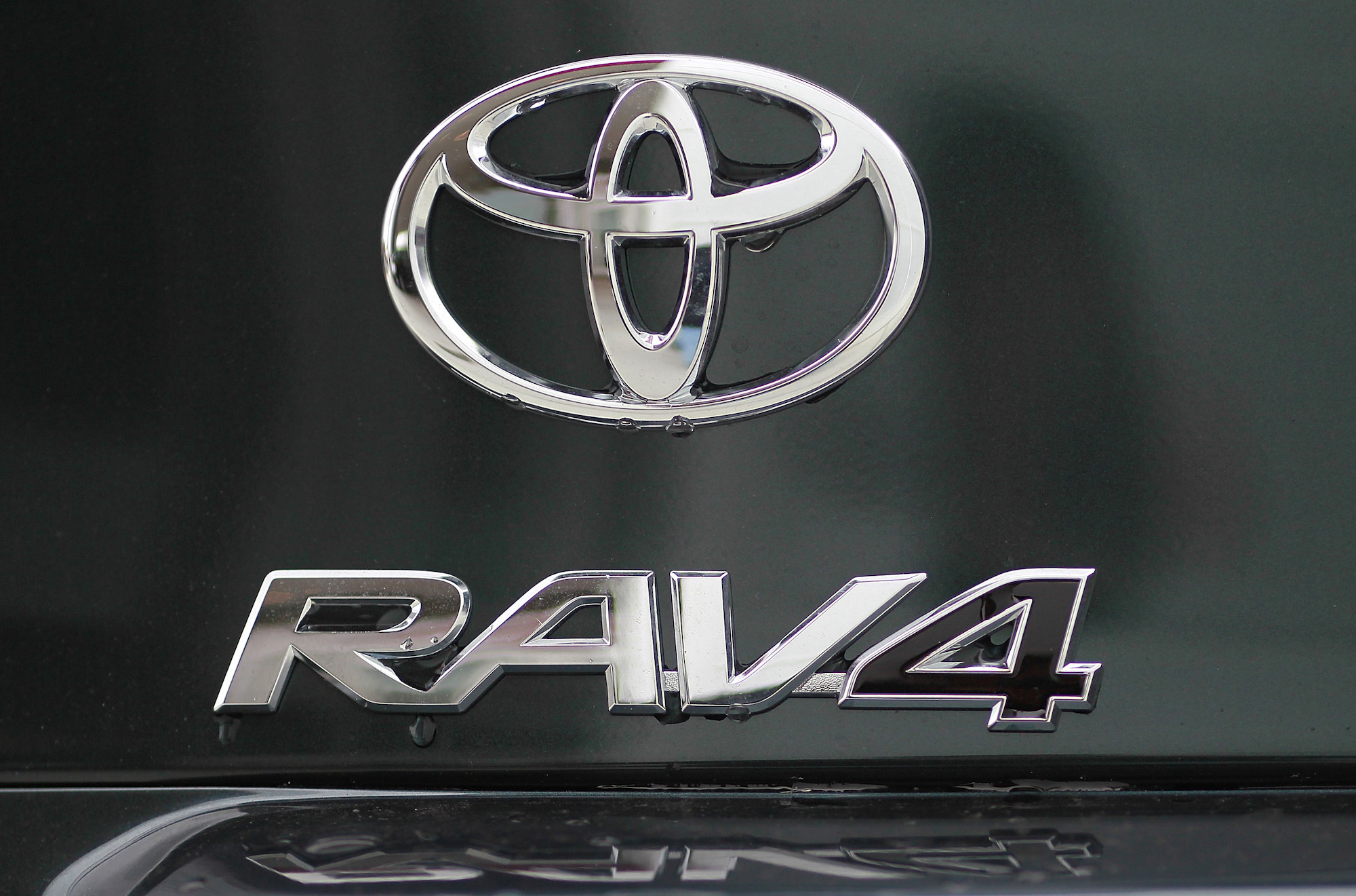 The Toyota and RAV4 logos displayed on the back of a Toyota RAV4 at a dealership in Oakland, California, in 2011