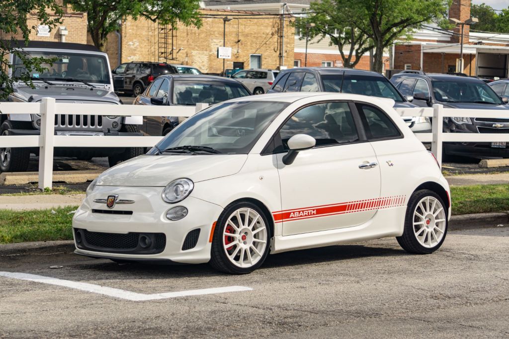 The author's white-and-red 2013 Fiat 500 Abarth on a city street