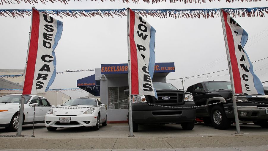 A used cars lot with flags and used cars.