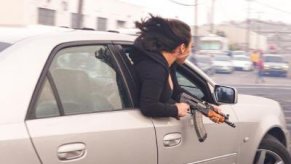 Woman in CTS-V with AK-47 assault rifle