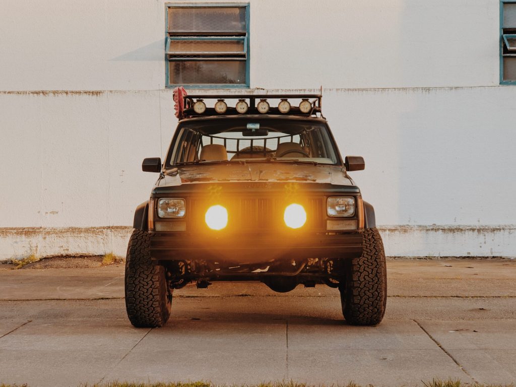 Jeep Cherokee front grill with added lights on a 90s overlander
