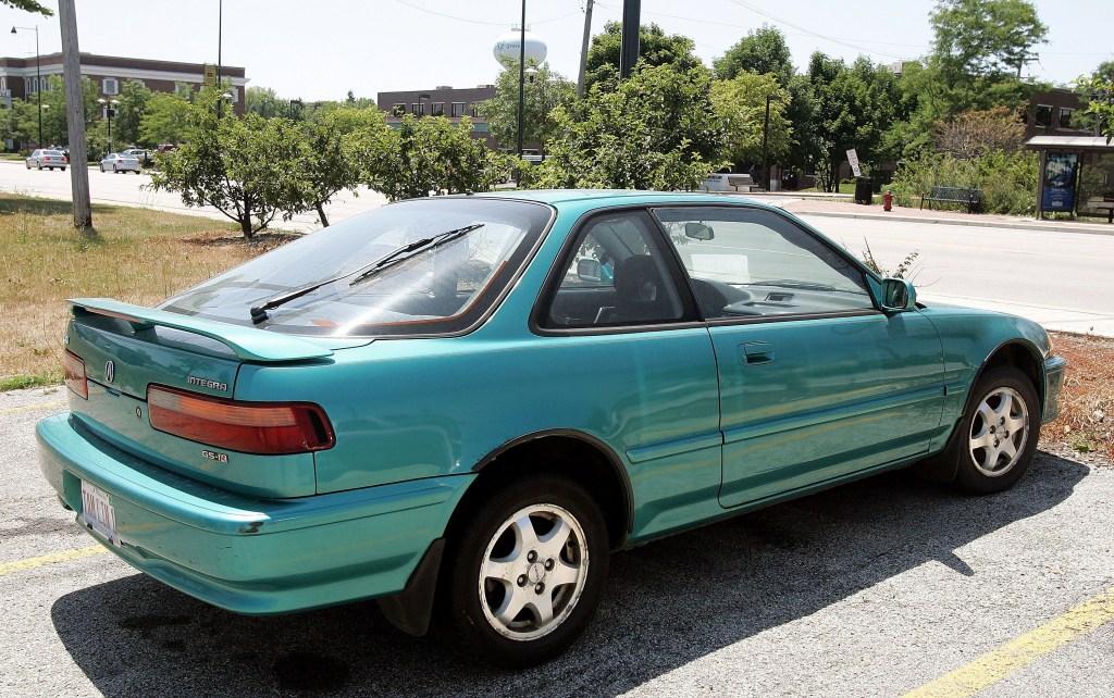  An older model Acura Integra is seen in a parking lot.