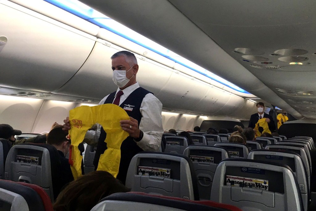Flight attendants checking safety precautions in an airplane cabin before takeoff