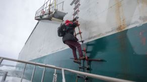 A harbor pilot climbing a boat ladder in Boston Harbor of Boston, Massachusetts