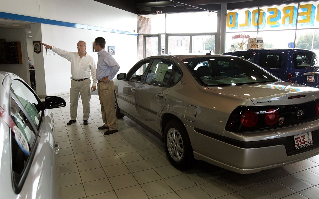 Sales and leasing consultant Ernie Alvinito, left, assists customer Bill Valasek in the new-car showroom at Hoskins Chevrolet, a division of General Motors.