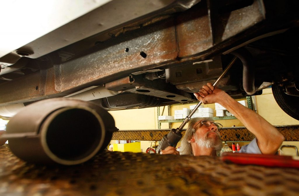 Mechanic installing a catalytic converter.