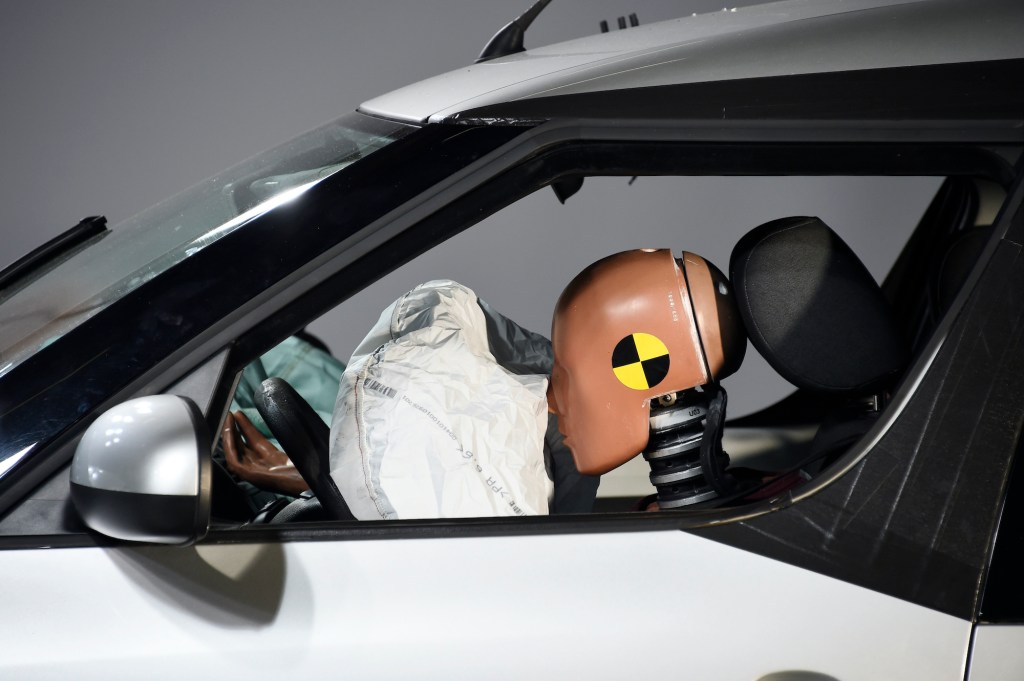 A car and its airbag are pictured after a frontal crash test with another car. 