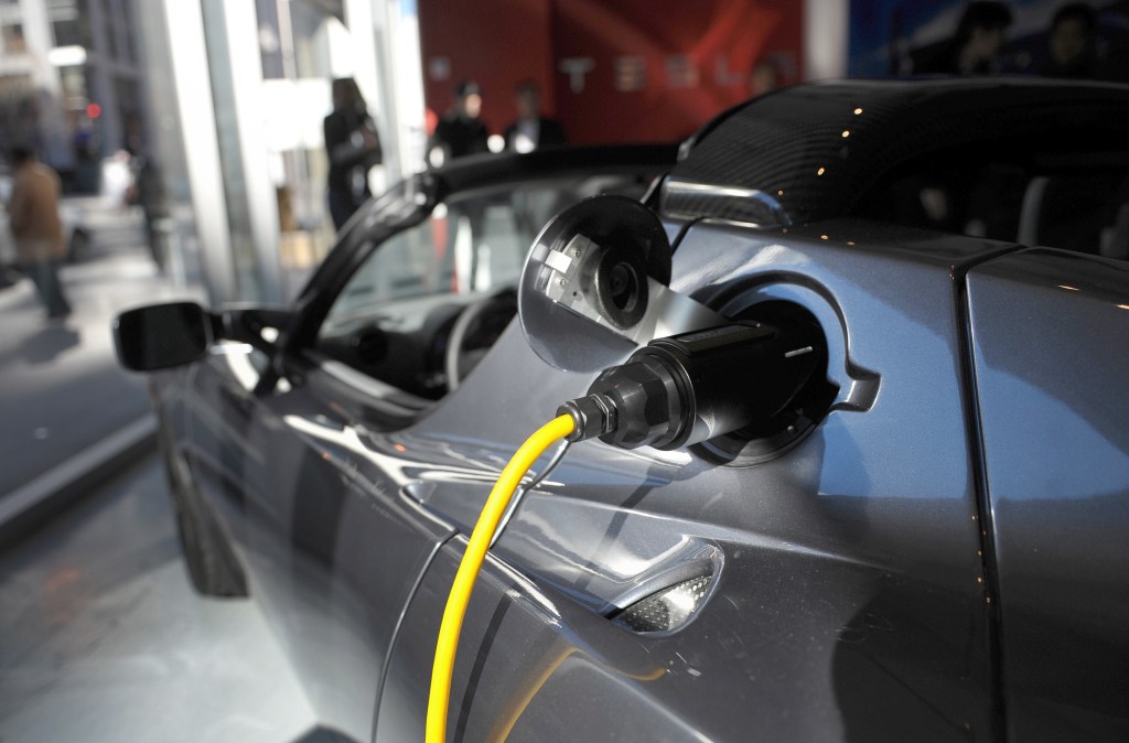 original Tesla Roadster plugged in to charge electric batteries
