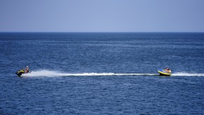 A jet ski tows people riding an inflatable tube in the Baltic Sea in June 2021