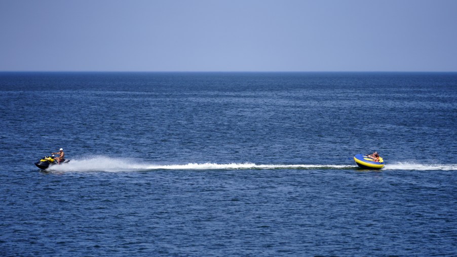 A jet ski tows people riding an inflatable tube in the Baltic Sea in June 2021