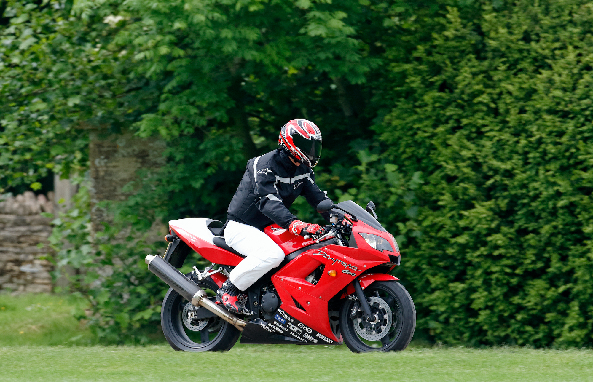 Prince William wears a motorcycle helmet as he rides a Triumph Daytona 600 motorbike in July 2005