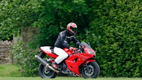 Prince William wears a motorcycle helmet as he rides a Triumph Daytona 600 motorbike in July 2005