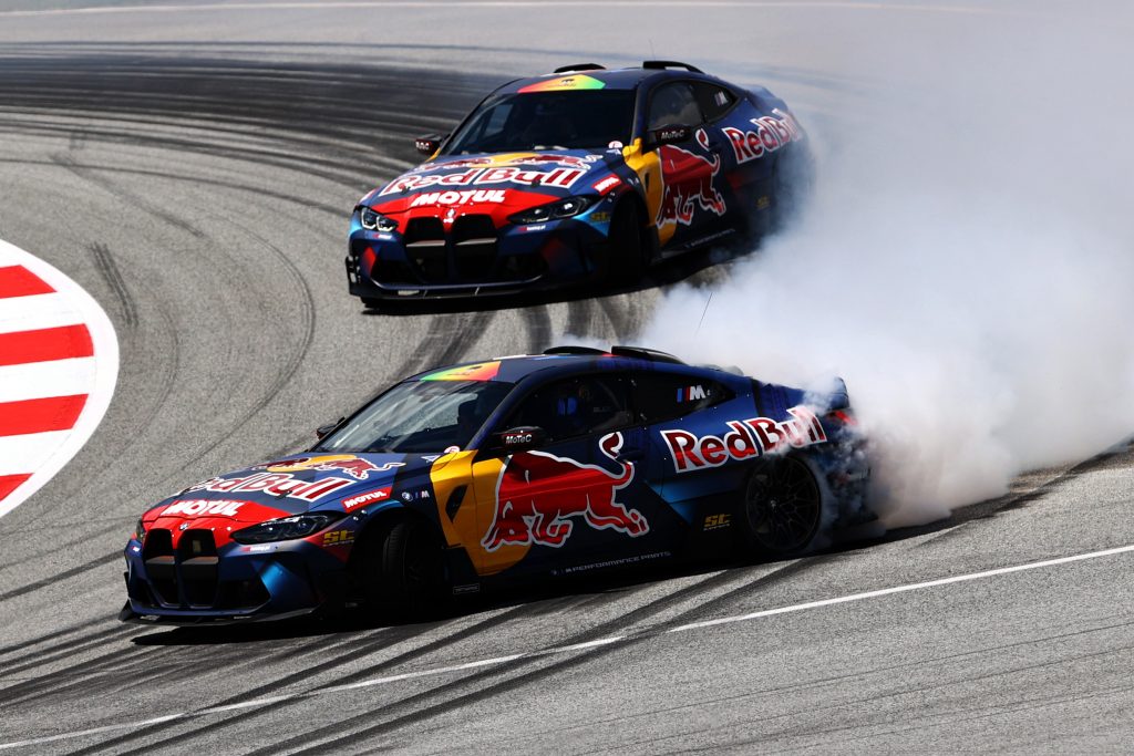 Two Red Bull Cars drifting around a track