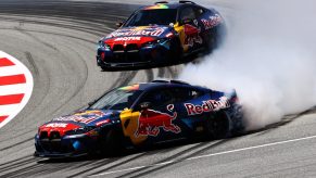 Two Red Bull drift cars drifting around a track