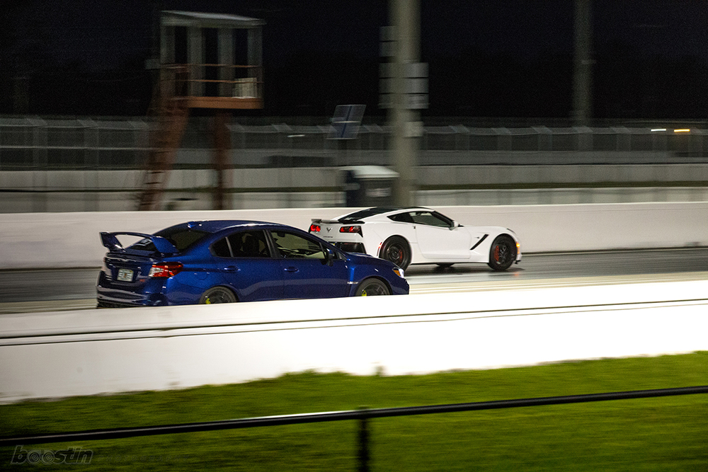 A Subaru and a Corvette Roll Race at a Track