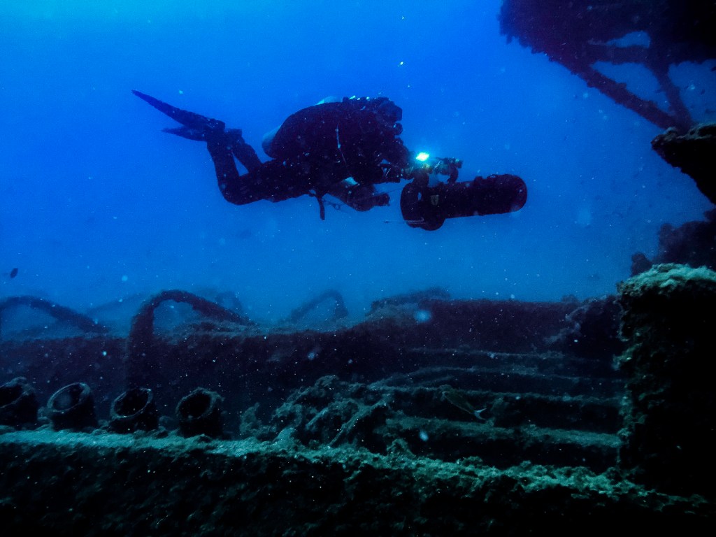 A scuba diver uses a sea scooter, also known as a diver propulsion vehicle (DPV), at a shipwreck in August 2017 outside Bonassola Liguria, Italy