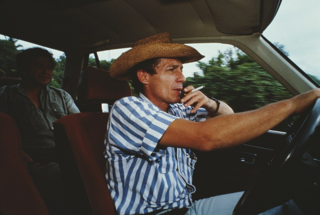 A man smokes a cigarette while driving