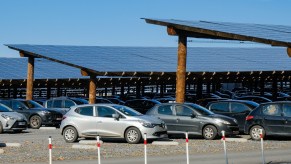 Cars in a parking lot covered by solar panels.