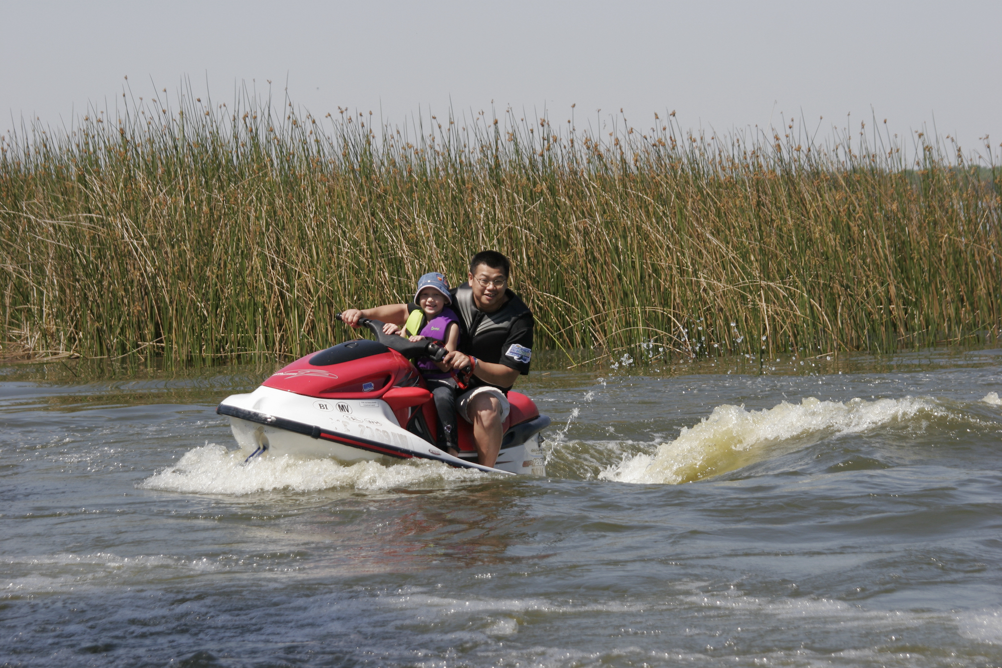 A man and a child ride a WaveRunner on Lake Parker in Lakeland, Florida