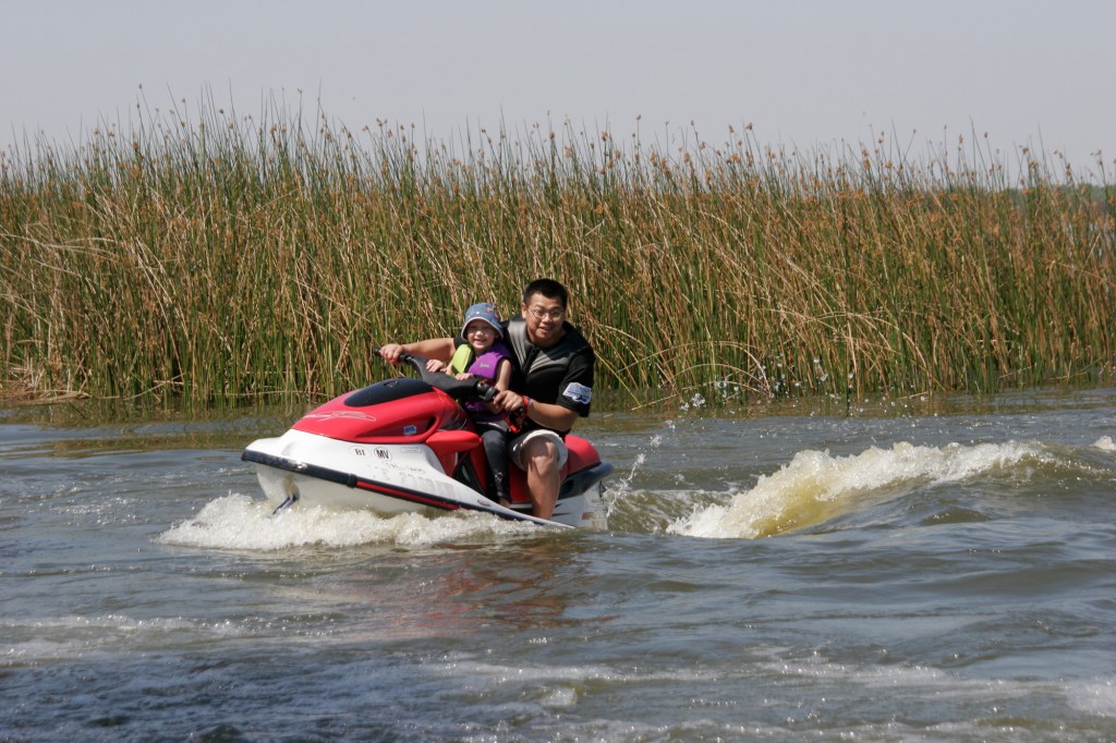 A man and a child ride a waverunner on Lake Parker in Lakeland, Florida
