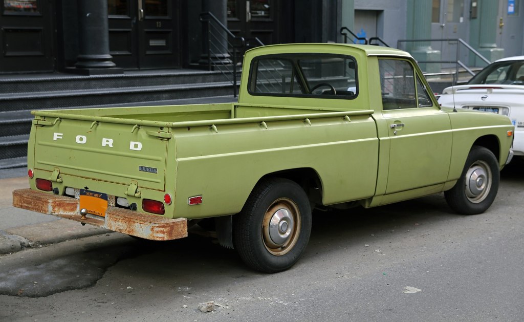 A green 1975 Ford Courier parked on the street