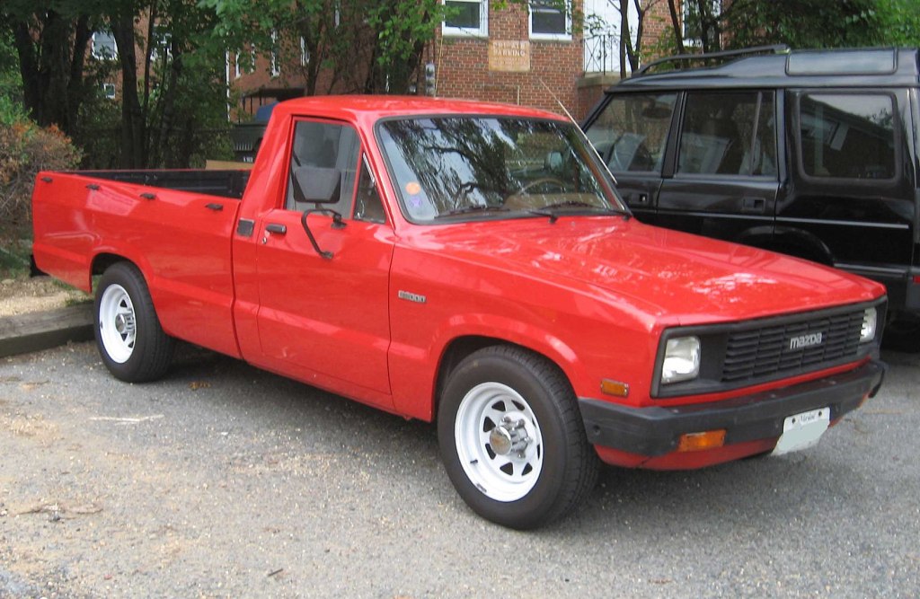 A red 1977 Mazda B-Series parked outside