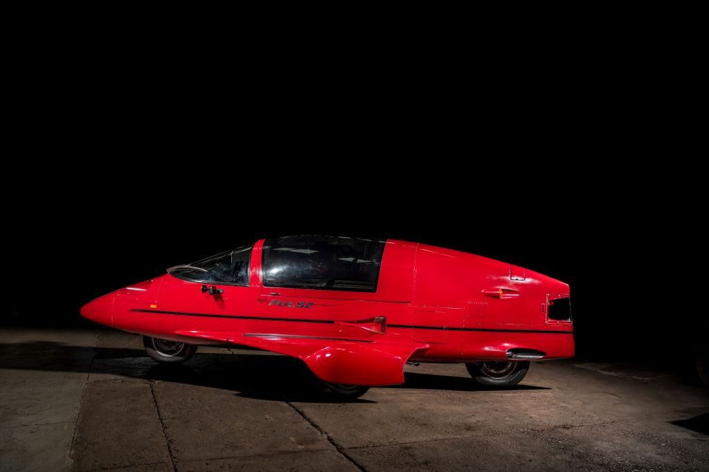 The side 3/4 view of a red 1985 Pulse Litestar Autocycle