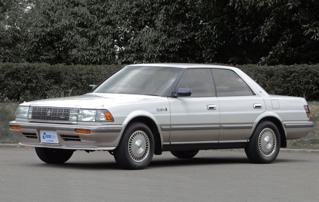 A white-and-gray 1988 Toyota 'S130' Crown Royal Saloon