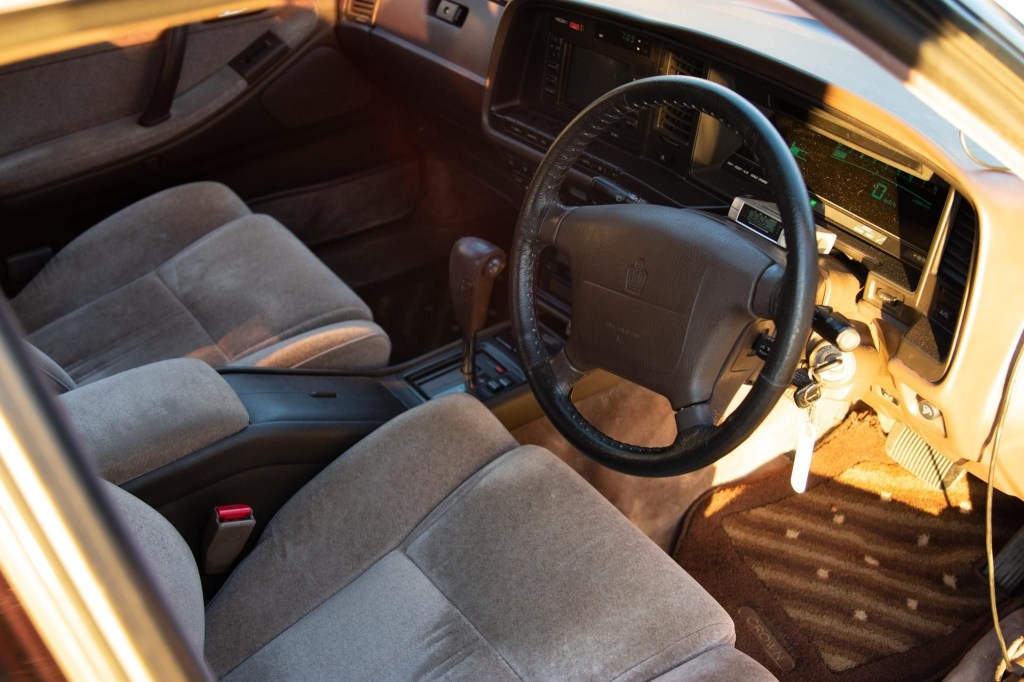 The brown-gray-velour-upholstered front seats and brown dashboard of a JDM 1991 Toyota Crown