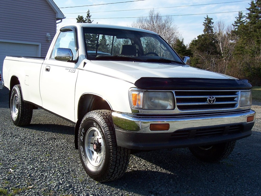 A white 1993 Toyota T100 is parked outside