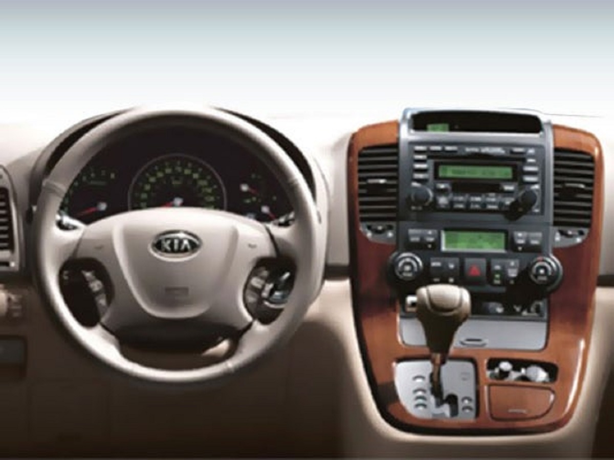 The steering wheel and shifter inside a 2008 Kia Sedona.