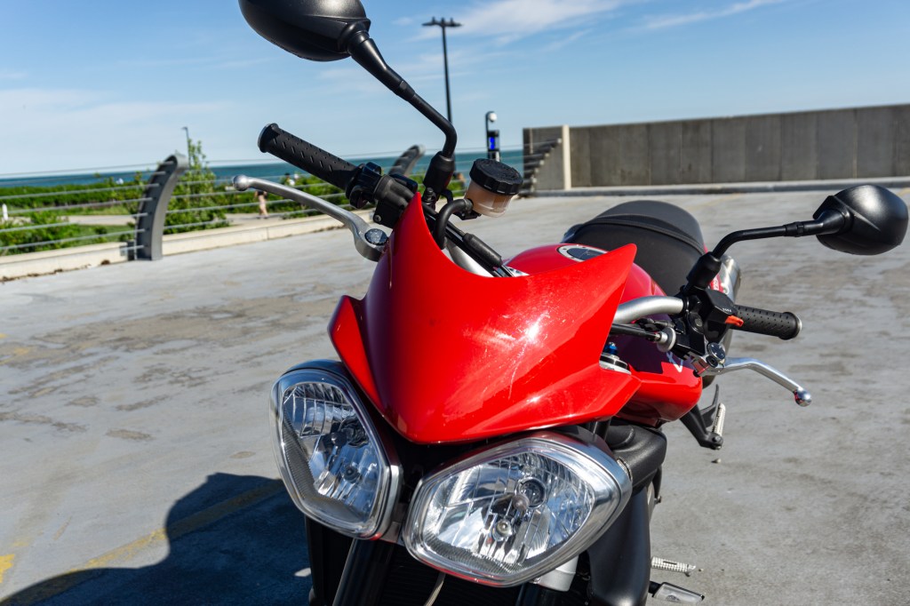 A close-up view of a red 2012 Triumph Street Triple R's flyscreen