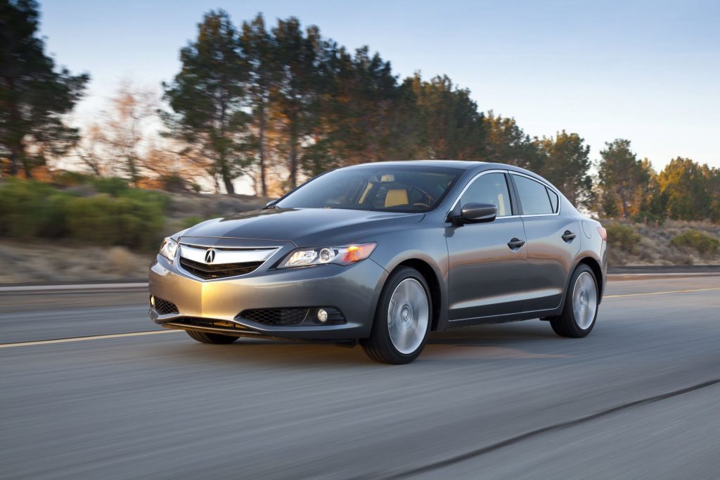 A silver 2013 Acura ILX driving on a highway