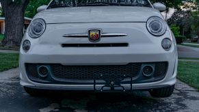 A white 2013 Fiat 500 Abarth with a black CravenSpeed Platypus front license plate holder