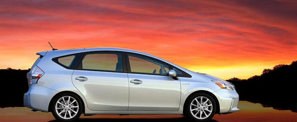 A 2014 Toyota Prius in front of a sunset and water