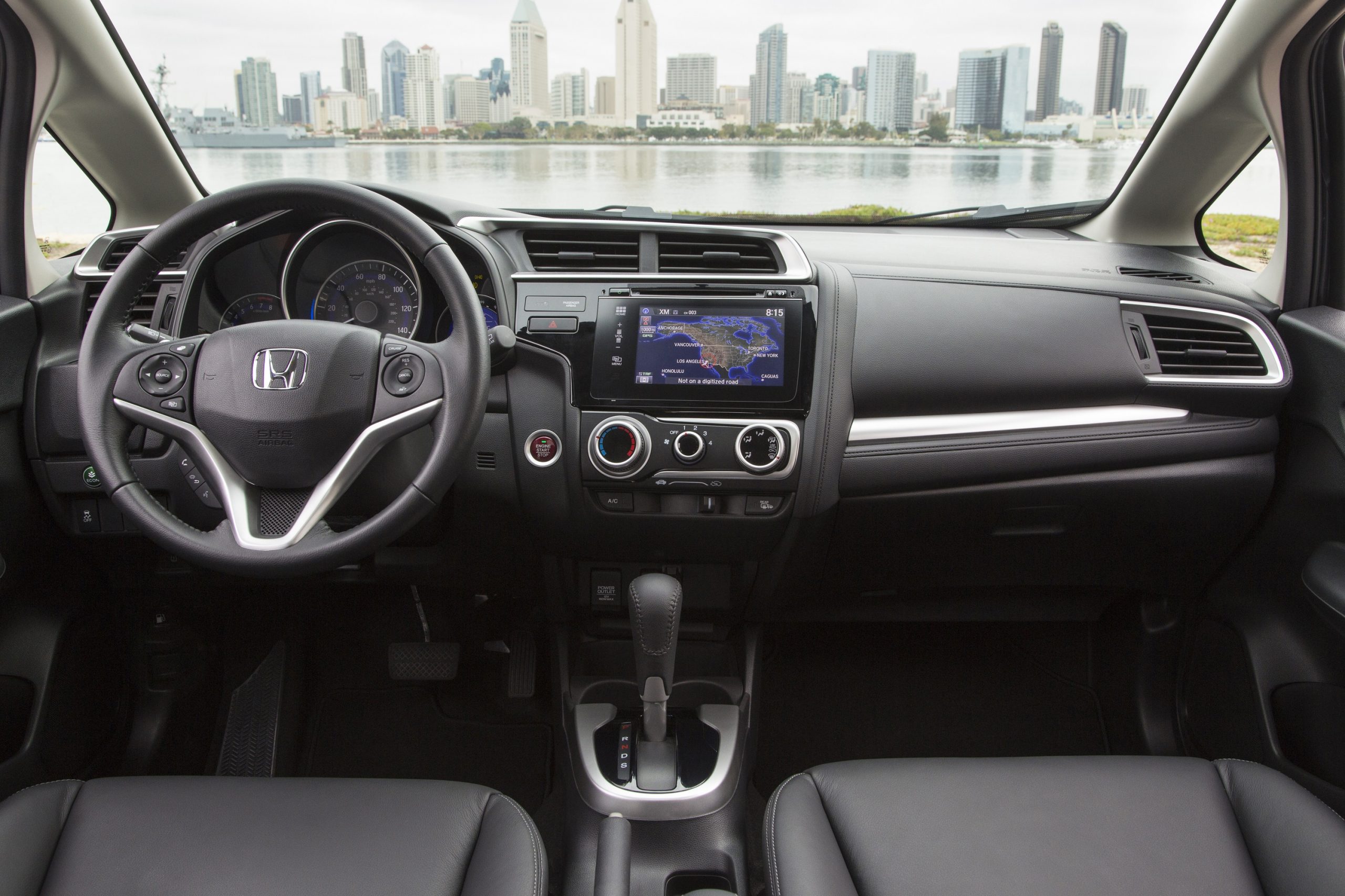 The interior of the 2015 Honda Fit with a conventional layout featuring the infotainment and climate control settings in the middle of the car
