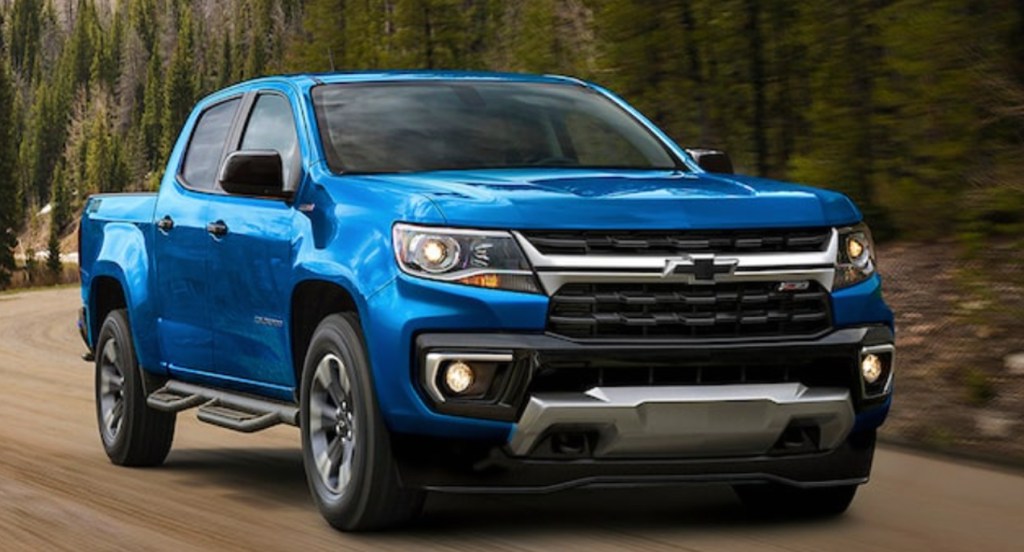 A blue 2021 Chevrolet Colorado is driving on the road. 