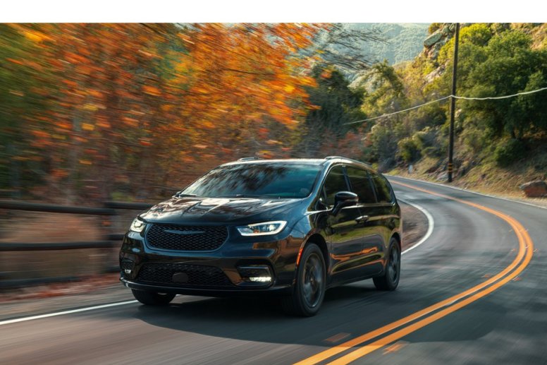 A black 2021 Chrysler Pacific driving on a road with a fall background