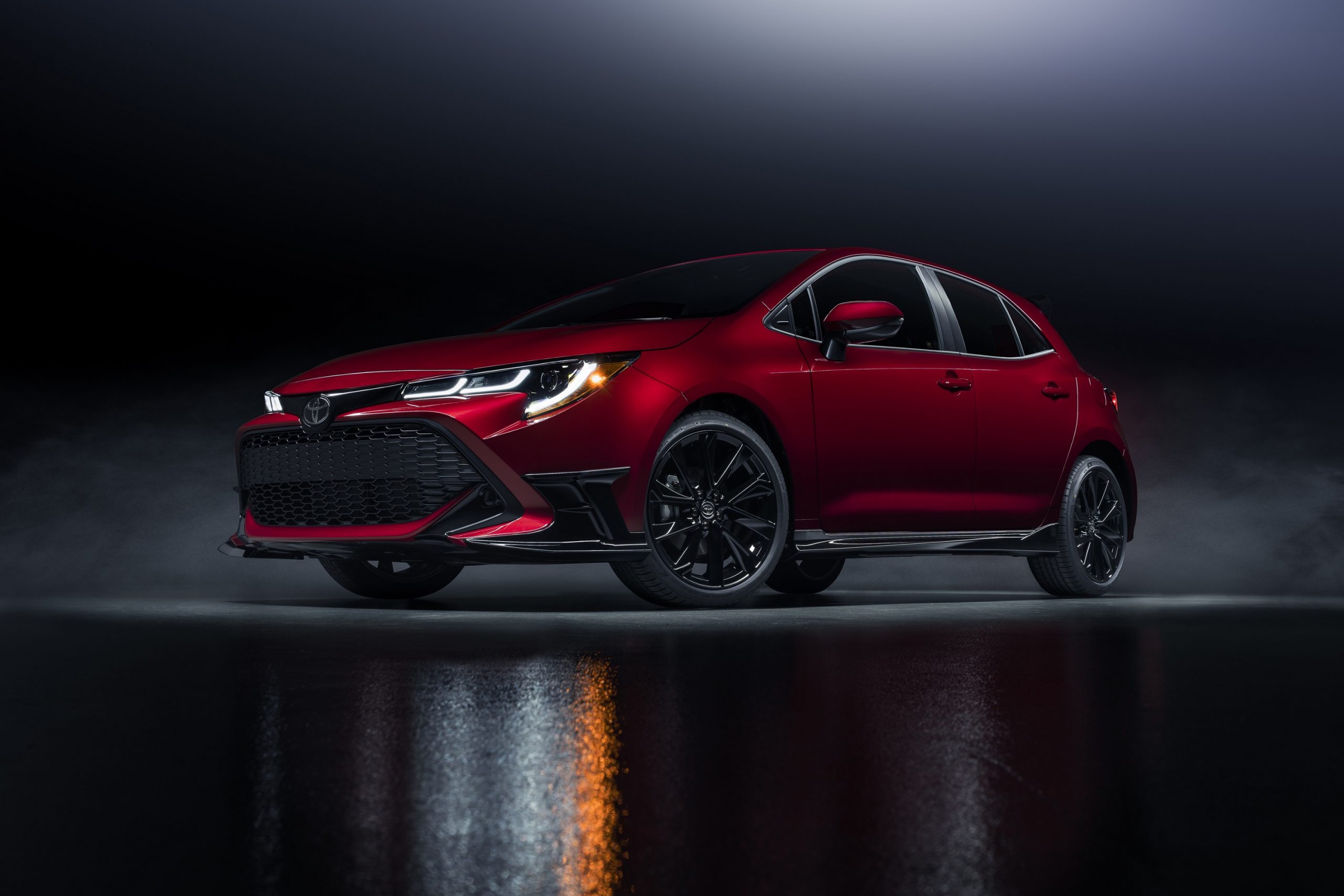 A red 2022 Toyota Corolla hatchback shot from the low front 3/4 in a studio