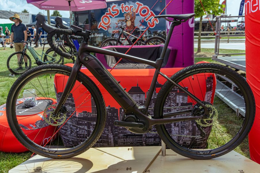 The side view of a dark-purple 2021 Giant Revolt E+ Pro on a stand