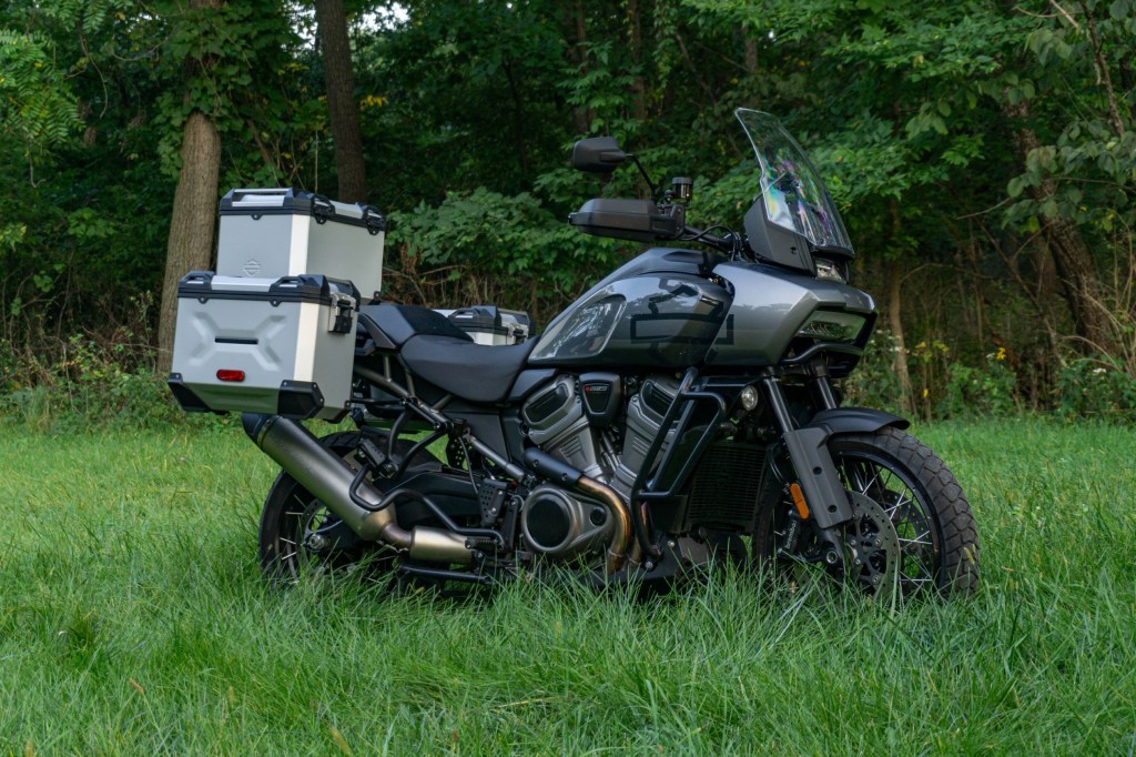 A gray-and-black 2021 Harley-Davidson Pan America 1250 Special with accessories in a grassy field