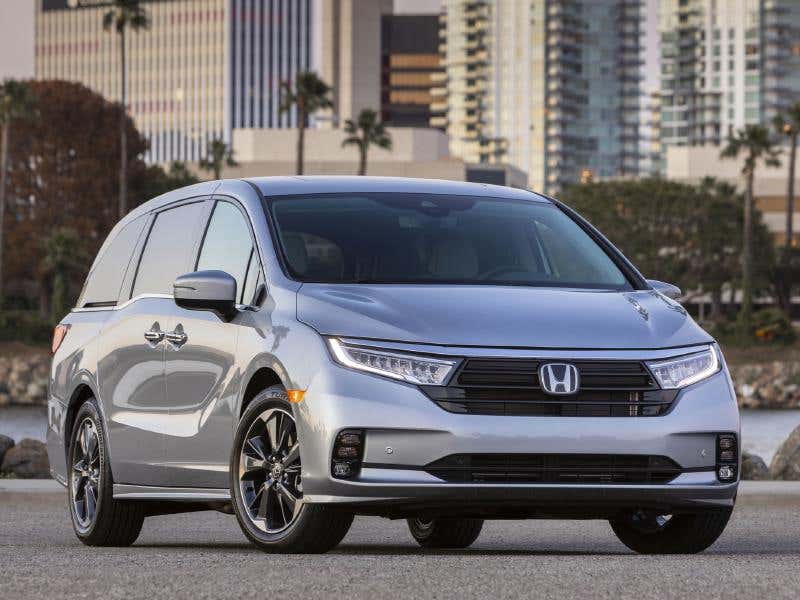 A silver 2021 Honda Odyssey parked outside with a city background