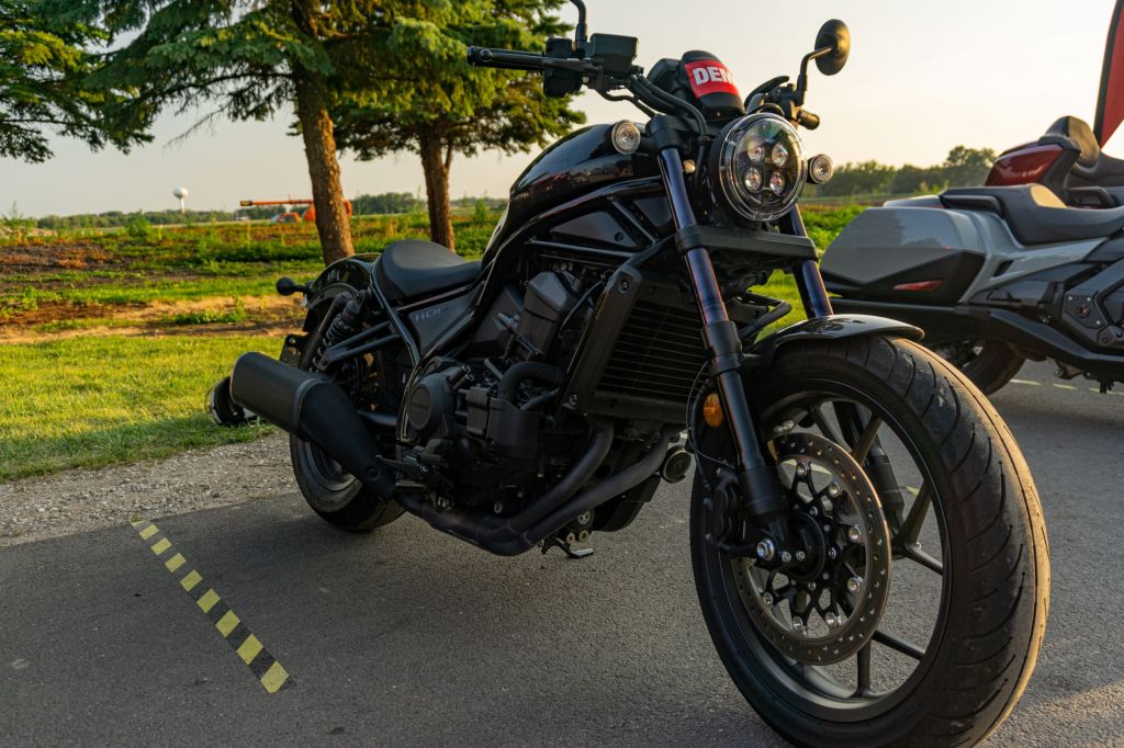 The front 3/4 view of a black 2021 Honda Rebel 1100 DCT in a parking lot
