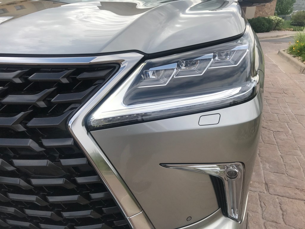 Headlight shot of the 2021 Lexus LX 570 as it sits in a parking lot driveway for our full review.