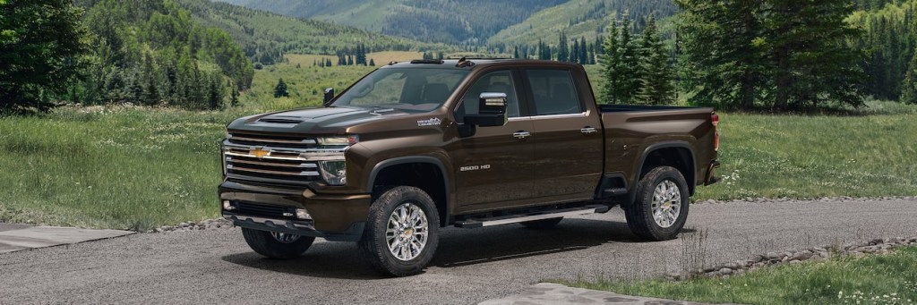 2021 chevrolet silverado high country in brown parked outside near a mountain and forest