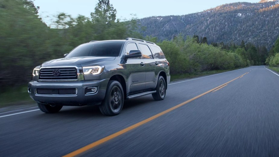A 2021 Toyota Sequoia drives down an empty road at night.