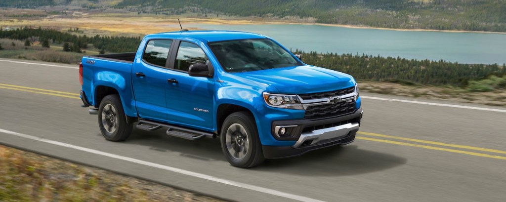 a bright blue 2021 Chevy Colorado driving at speed on a country highway